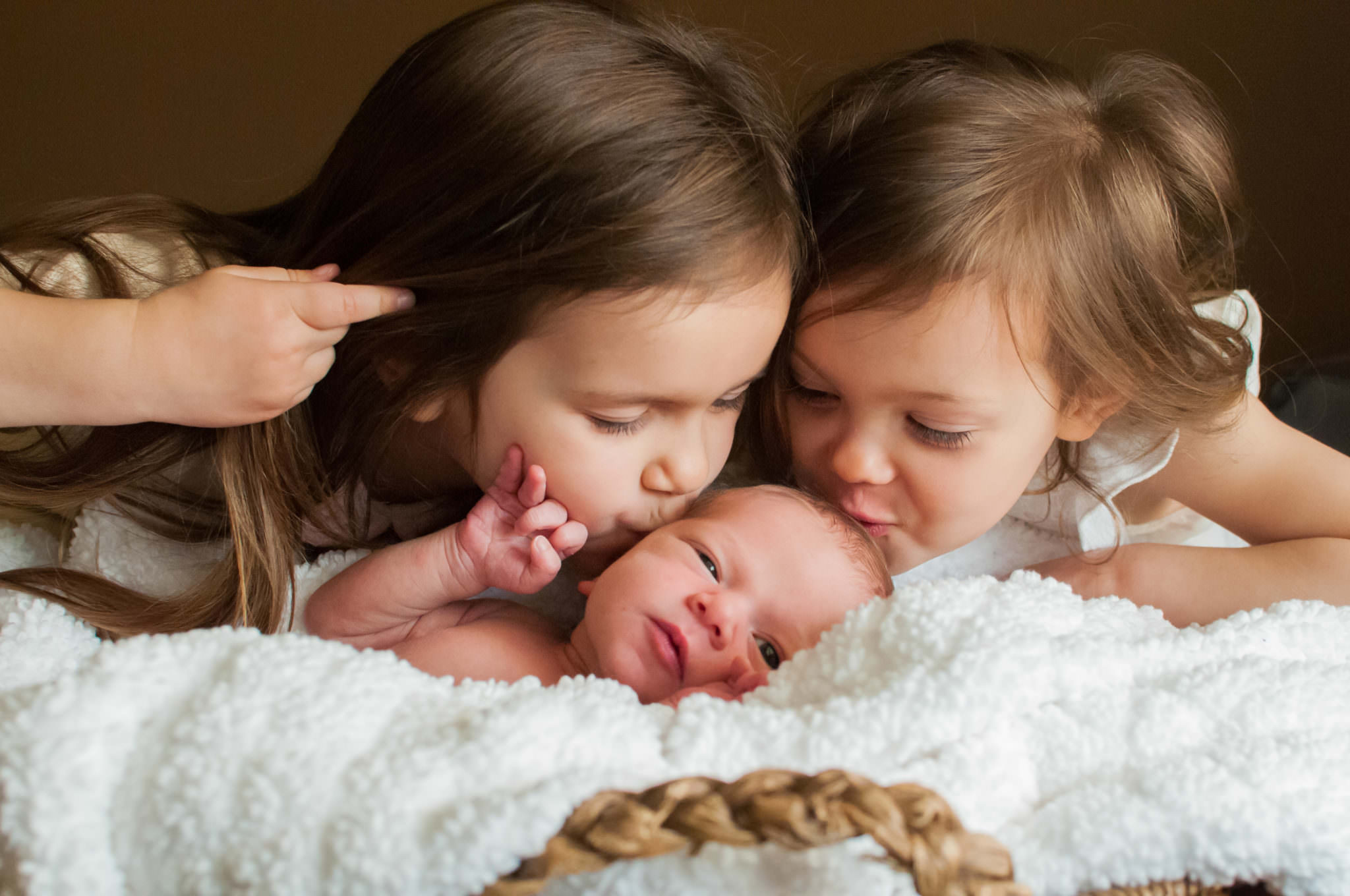 Two sisters kissing brother, Livonia Newborn Photography