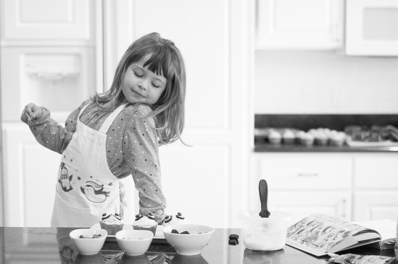 young girl decorating cupcakes in the kitchen, Northville Child Photography