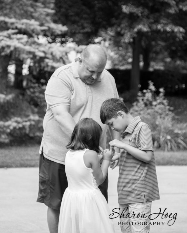 Kids and dad in the yard looking at something together, Northville Family Photographer